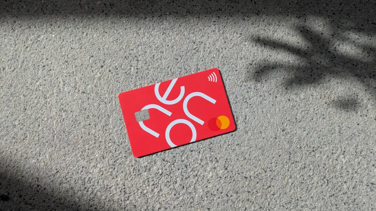 Red Neon debit Mastercard on concrete surface with soft shadow – Swiss digital bank